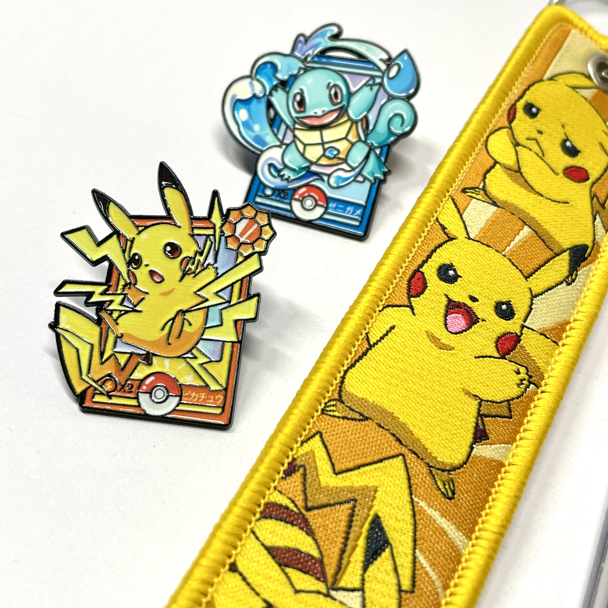 Primer plano de llavero Pikachu de tela junto a accesorios Pokémon
