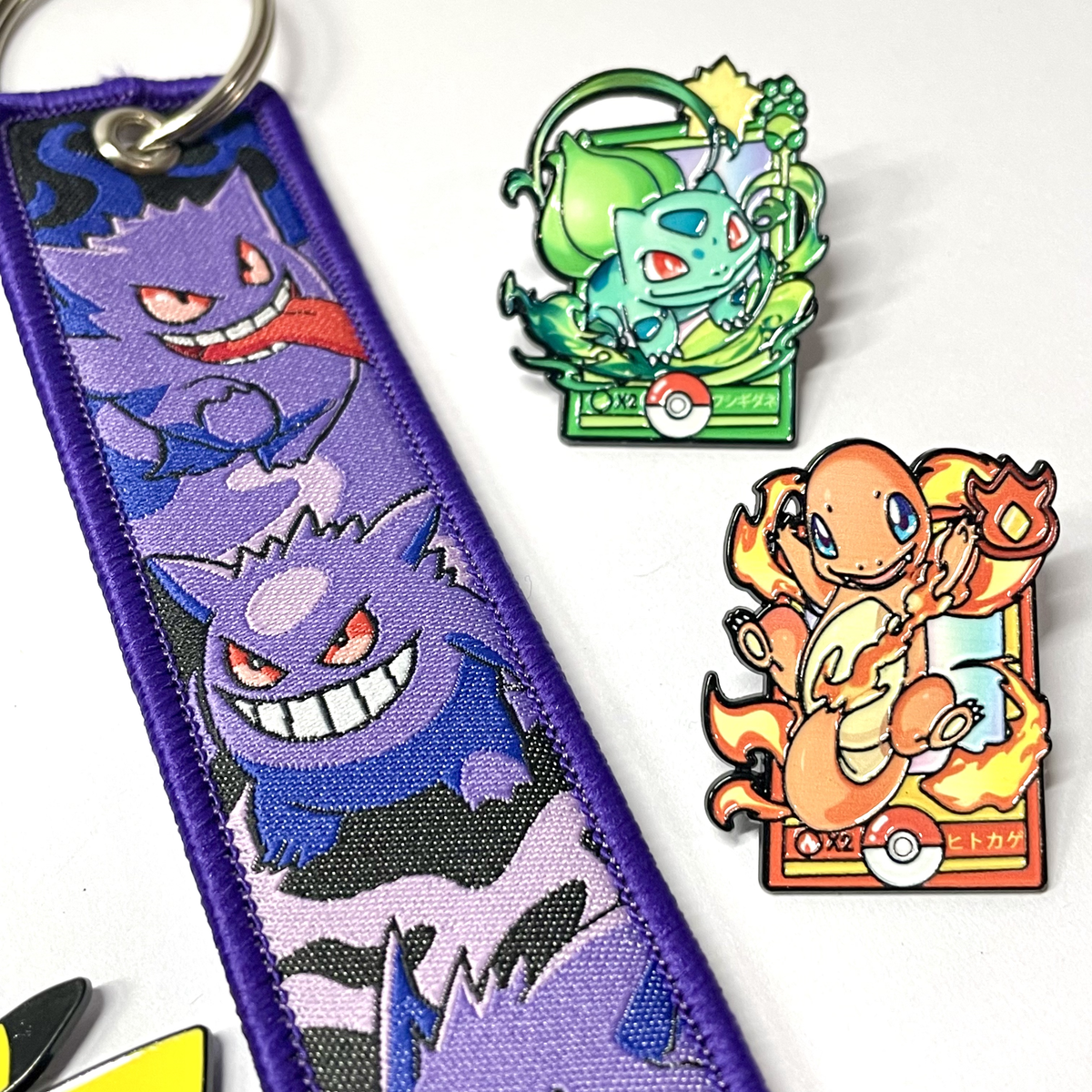 Primer plano de llavero Gengar de tela junto a accesorios Pokémon